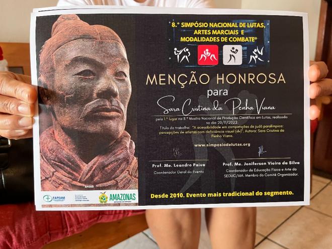 Sara recebeu um certificado de Menção Honrosa, pelo 1º lugar no 8º Simpósio Nacional de Lutas, Artes Marciais e Modalidades de Combate