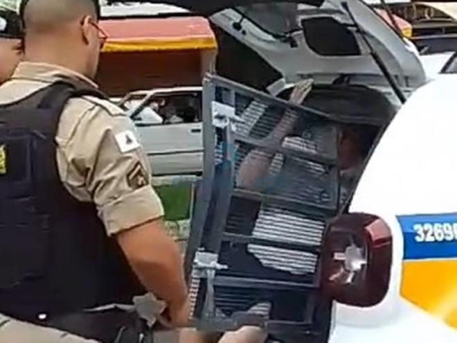 O momento que o motorista do Gol é colocado na viatura da PM