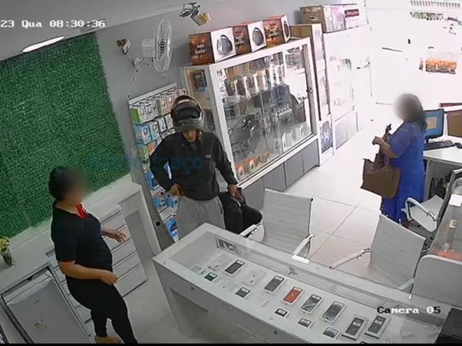 O momento que o bandido exige os celulares que estavam no mostruário do balcão