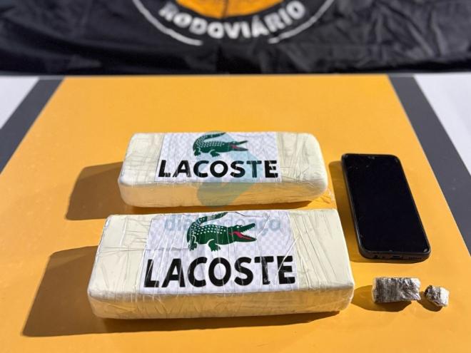 Foram localizadas na bagagem do passageiro duas barras de pasta base de cocaína, um tablete de maconha e um celular