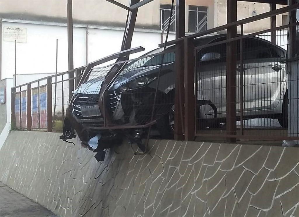 Sedan ficou pendurado na cerca que divide estaciomamento do Supermercado Garcia e a calçada da avenida Livramento  