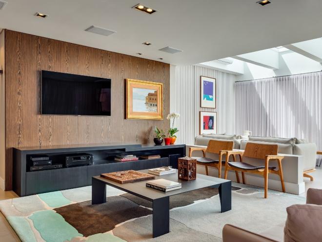 Viés artístico: Com ares contemporâneos, nessa sala de TV são as obras de arte que dividem espaço com o conforto do sofá. O tapete Henning Kuwow, a mesa de centro e as cadeiras de jantar Jader Almeida e a gravura de Burle Marx são alguns dos itens conceituados desse ambiente projetado pela Volpi Arquiteta