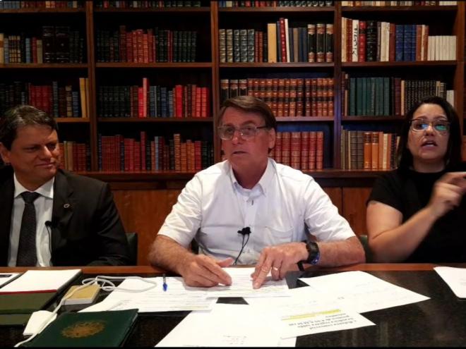Jair Bolsonaro, ao lado de intérprete de libras e do ministro da Infraestrutura, Tarcísio Freitas  