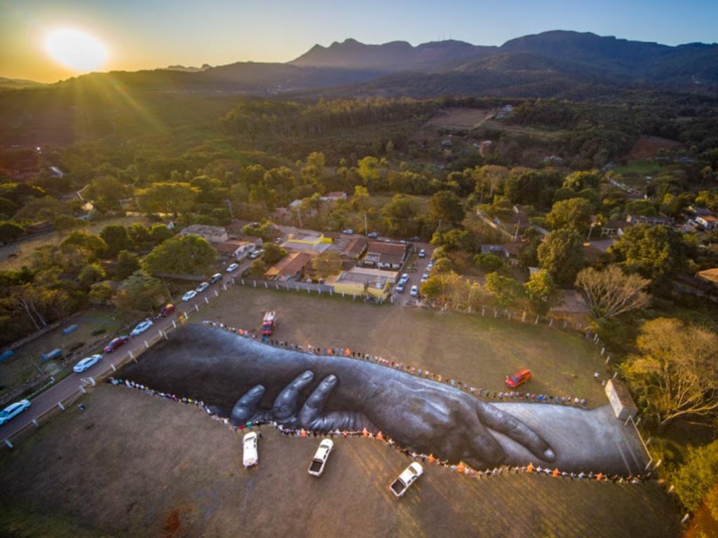 População de Brumadinho dá abraço coletivo em torno de obra de arte de Saype: união e solidariedade